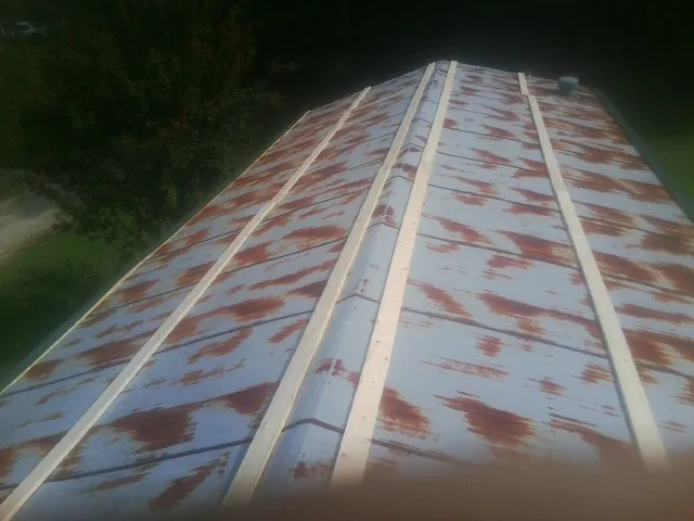 Rusted metal roof panels with new wood purlins before replacement — Storm Damage Roof Repair in Mcdonough by Roofing Brothers