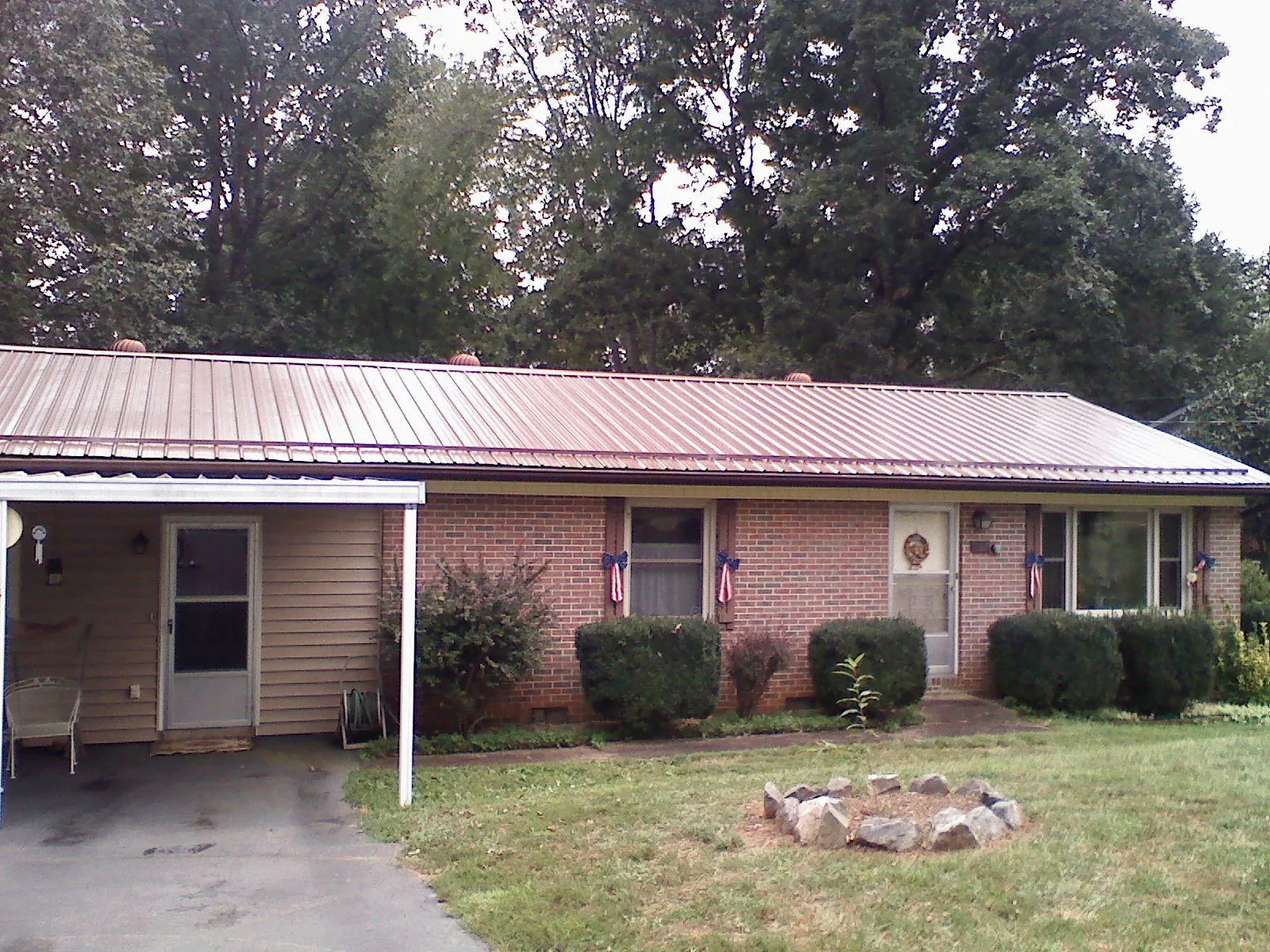 Bronze metal roof and carport on a brick ranch home — Roof Repair work by our crew in Mcdonough