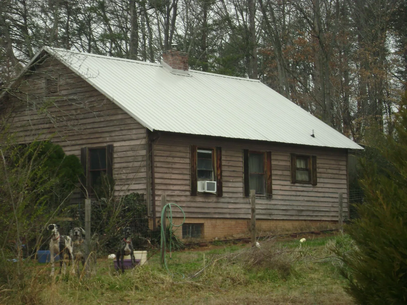 White metal roof on an old wood sided farmhouse, from a Metal Roof Installation job in Mcdonough